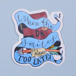 May include: A white sticker with blue and red accents. The sticker features a cartoon illustration of a Dungeon Master with the text "When the DM smiles it's already too late!"