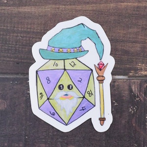May include: A purple and green 20-sided die with a cartoon face wearing a blue wizard hat and holding a gold wand with a red gem on top. The die has numbers 4, 6, 8, 10, 12, 18, 2, and 11 on its sides.