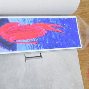 Fuzzy red demon under the stars bookmark, creepy spirit page holder with tassel, spooky Halloween book accessory