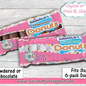 Op de afbeelding: Roze en witte donut-traktatiezakjes met een blauw en geel ontwerp. De zakjes zijn gelabeld met "Kamala's Chocolate Donuts" en "Kamala's Powdered Donuts". De zakjes zijn ontworpen om 3 oz 6-pack donuts te passen.