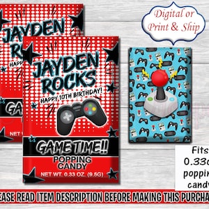 Puede incluir: Bolsas de fiesta rojas y negras con temática de videojuegos. Las bolsas presentan un fondo rojo con lunares blancos y estrellas negras. El texto en las bolsas dice "Jayden Rocks Happy 10th Birthday!" y "Game Time!! Popping Candy Net Wt. 0.33 oz. (9.5g)".