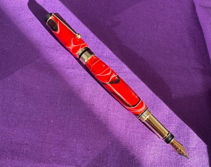 Red swirl resin fountain pen with gold fittings, handcrafted in Scotland
