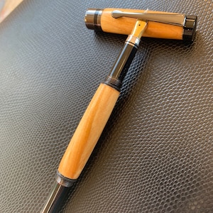 Pluma estilográfica hecha a mano en madera de sauce británico con acabado en accesorios de bronce.