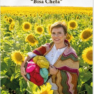 Puede incluir: Una portada de libro titulada LA HEBRA QUE NOS UNE Bisa Chefa que muestra a una persona sosteniendo una cesta de ovillos de lana de colores y vistiendo un chal de ganchillo con patrón de zigzag en un campo de girasoles amarillos.