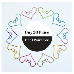 May include: A circle of 20 pairs of colorful heart-shaped metal clips. The circle is centered around a black circle with white text that reads "Buy 20 Pairs Get 1 Pair Free".