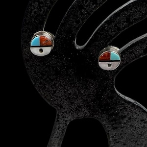 May include: A pair of circular stud earrings featuring a split design with one half in bright turquoise and the other half in reddish-brown stone, separated by a thin silver line and set within a polished silver frame with a central silver dot.