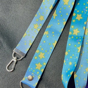 May include: Two blue and yellow star patterned lanyards with silver swivel clips.