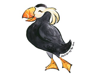 May include: A cartoon illustration of a black and white puffin with an orange beak and yellow feet. The puffin is smiling and has a white crest on its head. The text "Sketches by The Sea" is written in cursive below the puffin.
