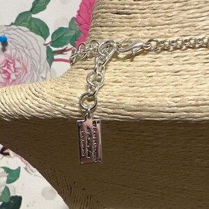 May include: Silver-toned necklace with a lobster clasp and a small rectangular tag. The tag has engraved text that reads "MY PLACE IN LONDON" and other text. The necklace is displayed on a tan mannequin head.
