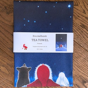 May include: Navy blue tea towel with a starry night sky design and a whimsical illustration of three figures looking up. The text "Eva melhuish TEA TOWEL Friends" is printed on a white band. Made from 100% cotton.