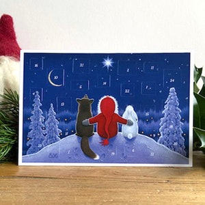 May include: A Christmas advent calendar featuring a dark blue night sky with a crescent moon and stars. Three cartoon characters, a fox, a person in a red coat, and a rabbit, are on a snowy hill. The calendar has numbered doors.