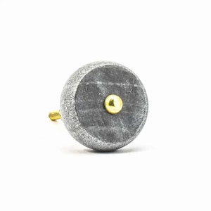 Peut inclure: Un bouton de porte rond en marbre gris avec un accent en métal doré.
