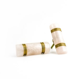 Può includere: Due tiretti per cassetti in marmo rosa e bianco con dettagli in filo d'oro.