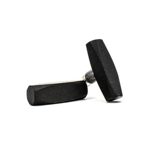 Op de afbeelding: Twee zwarte rubberen remblokken voor een fiets. De blokken zijn rechthoekig met afgeronde randen.