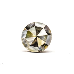 Peut inclure: Un bouton rond décoratif en nacre irisée. Le bouton est de forme géométrique avec différentes nuances de gris, de blanc et d'or.