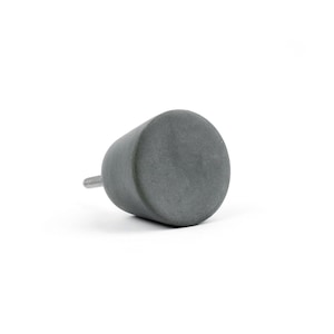 May include: A white ceramic mug with a black handle and the text "But First, Coffee" in a black, handwritten-style font. The mug is on a white surface.