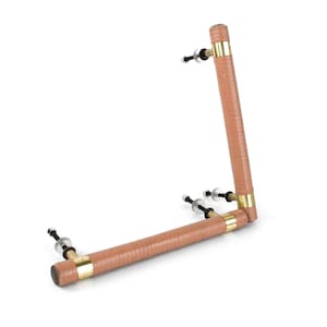 May include: A pair of cabinet door handles. The handles are made of light brown leather wrapped around metal tubes. The tubes are connected with brass fittings and have mounting hardware on each end. The handles are set against a white background.