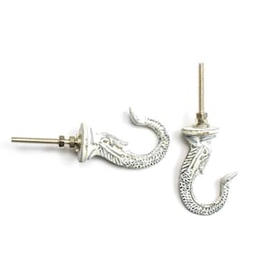 Puede incluir: Dos ganchos de metal blanco con forma de cola de sirena. Los ganchos tienen un diseño de tornillo para una fácil instalación.