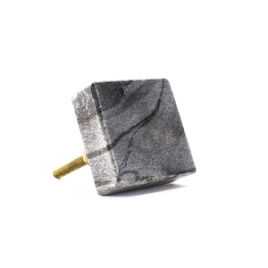 May include: A square grey marble cabinet knob with a gold screw.