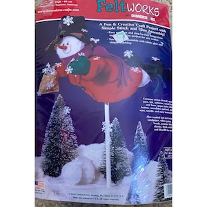 May include: Feltworks craft kit featuring a snowman design. The kit includes felt, yarn, patterns, and instructions for simple stitch and glue assembly. The finished product is approximately 18 inches high.