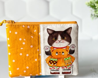 May include: A yellow and white polka dot fabric pouch with a zipper closure. The front of the pouch features a black and white cat wearing a red and yellow dress and holding a teddy bear. The text "GlassunShop" is printed on the bottom right corner of the pouch.