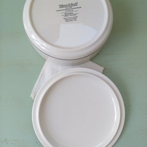 May include: White ceramic lidded storage container with a black and white label that reads "Villeroy & Boch" and "Botanica" on the bottom. The label also includes the text "Germany - Porcelaine" and "Dishwasher safe".