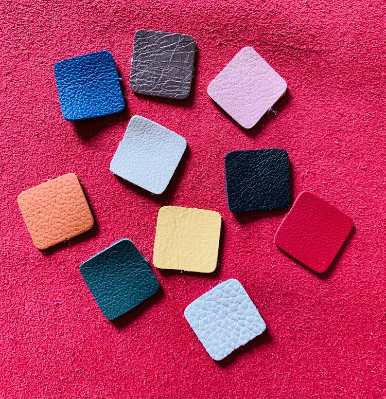 May include: Ten different colored leather squares, each with a unique texture. The squares are arranged in a circle on a red background.