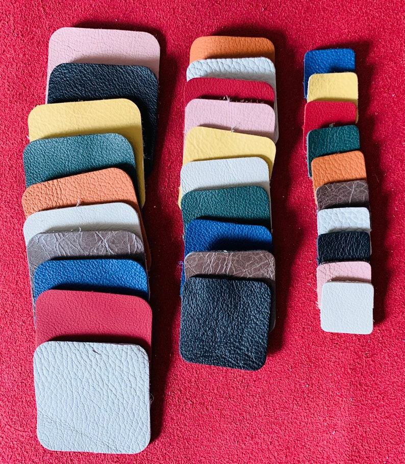 May include: A collection of leather swatches in various colors and textures, including pink, orange, yellow, green, brown, blue, red, and white. The swatches are arranged in two columns, with the left column containing 13 swatches and the right column containing 10 swatches.