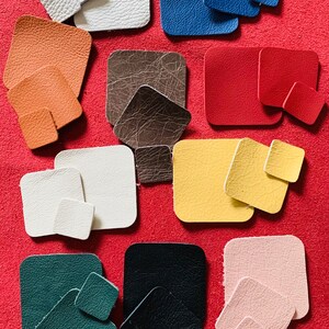 May include: Assortment of 10 different colored leather squares in various sizes. The squares are arranged in rows on a red background.