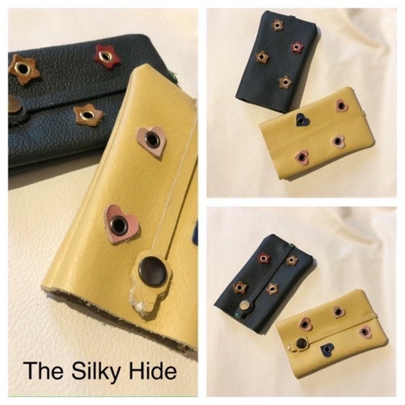 May include: Collage of leather wallets in yellow and dark blue. The wallets are decorated with star and heart-shaped accents. The text "The Silky Hide" is at the bottom of the image.