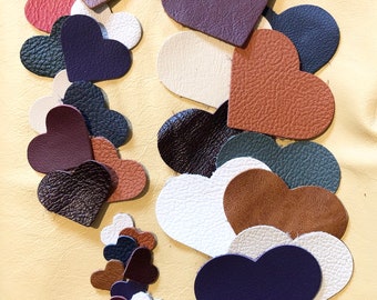May include: A collection of heart-shaped leather cutouts in various colors, including red, white, brown, and navy blue. The leather has a textured appearance. The Silky Hide is printed at the bottom right.