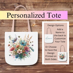 May include: A white tote bag with a floral design featuring a variety of colorful flowers. The bag has pink handles and the option to add a name to the back. The text "Design Options" is visible on the right side of the image.
