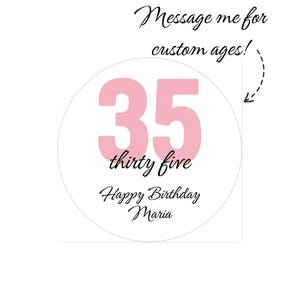 May include: A white circular design with the number "35" in pink, with the words "thirty five" below it. The text "Happy Birthday Maria" is below the number. The text "Message me for custom ages!" is above the number.