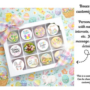 May include: A white box of Easter treats with colorful decorations. Each treat is round and decorated with Easter-themed images, including bunnies, eggs, and floral designs. The box is on a pastel Easter-themed background. Text on the box says "Happy Easter" and "Brooke".