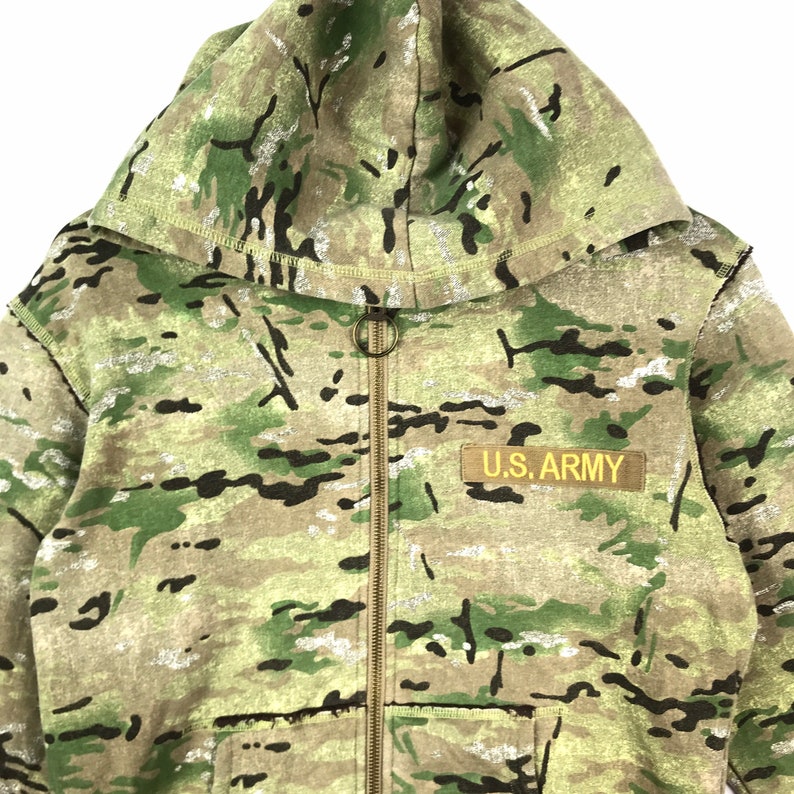 May include: A green, brown, and black camouflage hooded sweatshirt with a zipper closure and a U.S. Army patch on the front.