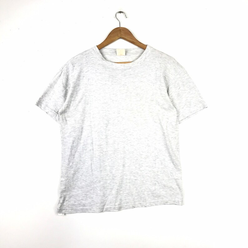 May include: A heather grey short-sleeved t-shirt hanging on a wooden hanger against a white background.