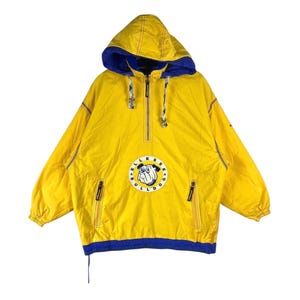 May include: Yellow and blue hooded anorak jacket with a half-zip closure. The jacket features a bulldog logo on the front and two zippered pockets. The hood and cuffs are blue, and the jacket has yellow stitching.