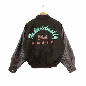 May include: A black and brown varsity jacket with leather sleeves. The back of the jacket features a green and white embroidered logo that says "Individually [ixiz] BASIC".