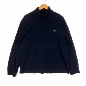May include: A black long-sleeve pullover with a quarter-zip closure and a small embroidered logo on the chest.
