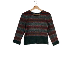 May include: A green, red, and purple striped sweater with long sleeves.