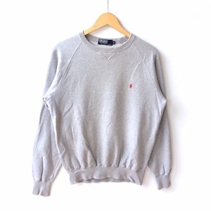 Peut inclure: Un sweat-shirt gris à manches longues avec un col rond et un petit logo de joueur de polo rouge sur la poitrine gauche. Le sweat-shirt a un ourlet et des poignets côtelés.