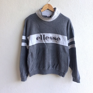 May include: A gray sweatshirt with a white stripe across the chest. The stripe has the word "ellesse" in black letters and the text "PERUGIA ITALIA DAL 1959" in smaller black letters.