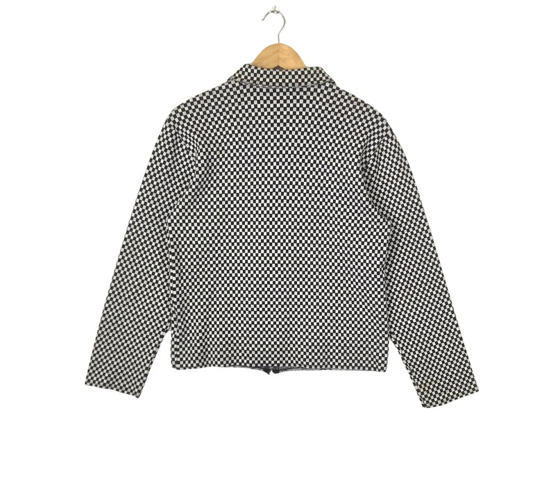 Puede incluir: Chaqueta a cuadros en blanco y negro con cierre de cremallera.