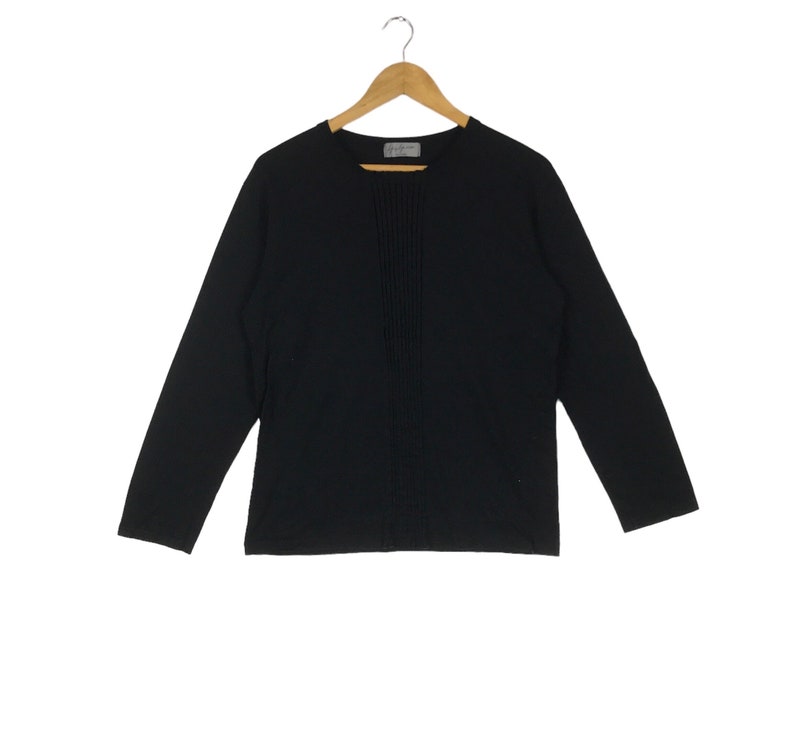 May include: A black long-sleeved shirt with a vertical seam down the front.