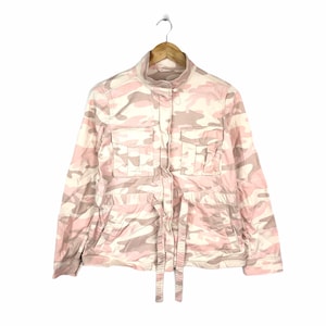 May include: A pink and white camouflage print jacket with a button front and a tie belt.