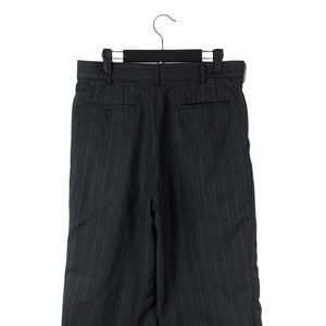 May include: Dark grey pinstripe trousers with a button fly and a back pocket. The trousers are hanging on a black hanger.