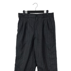 May include: A pair of dark grey pinstripe trousers with a pleat in the front. The trousers are hanging on a black hanger.