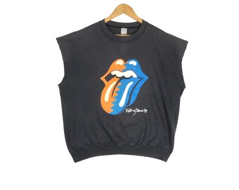 May include: Black sleeveless shirt with a blue and orange tongue graphic and the text "Rolling Stones" underneath.