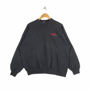May include: A dark gray sweatshirt with a red "IKON" logo on the front. The logo is in a bold, sans-serif font.