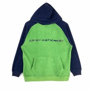 May include: A green and navy blue fleece hoodie with the text "gap athletic" in a stylised font on the front.